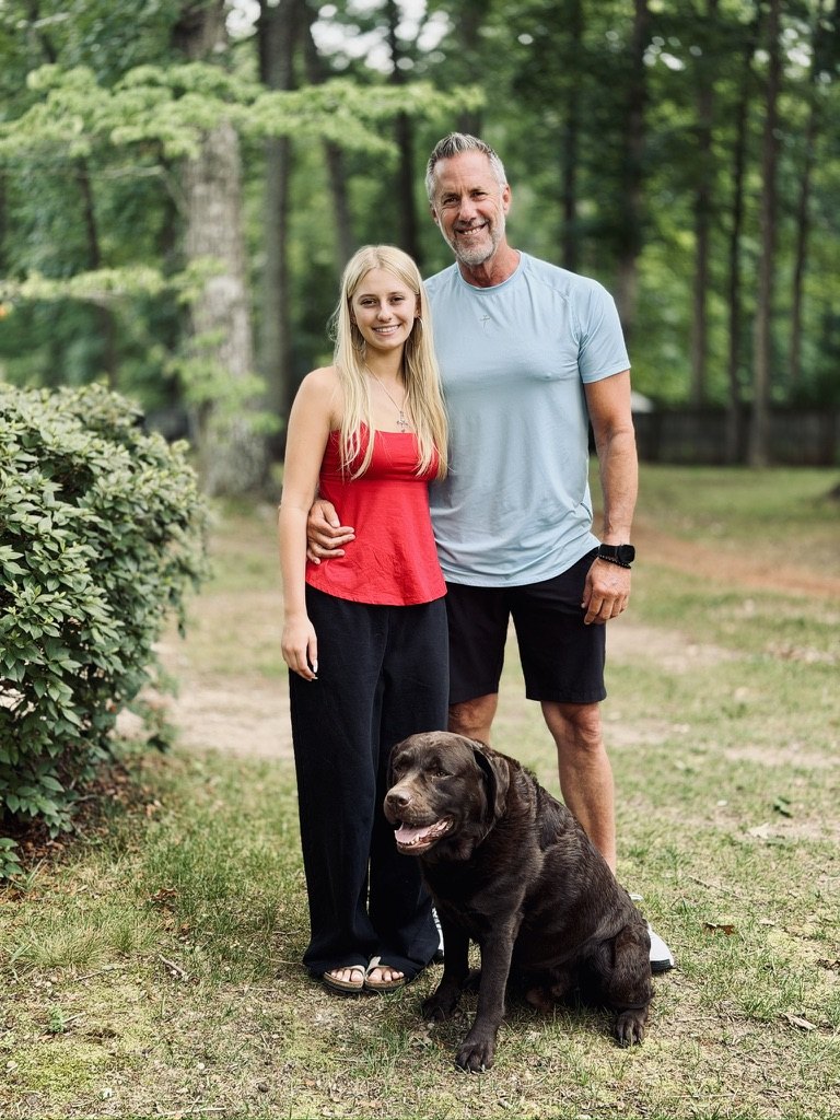 Scott Griggs with his daughter and their chocolate lab, Gunner, at home in Wake Forest